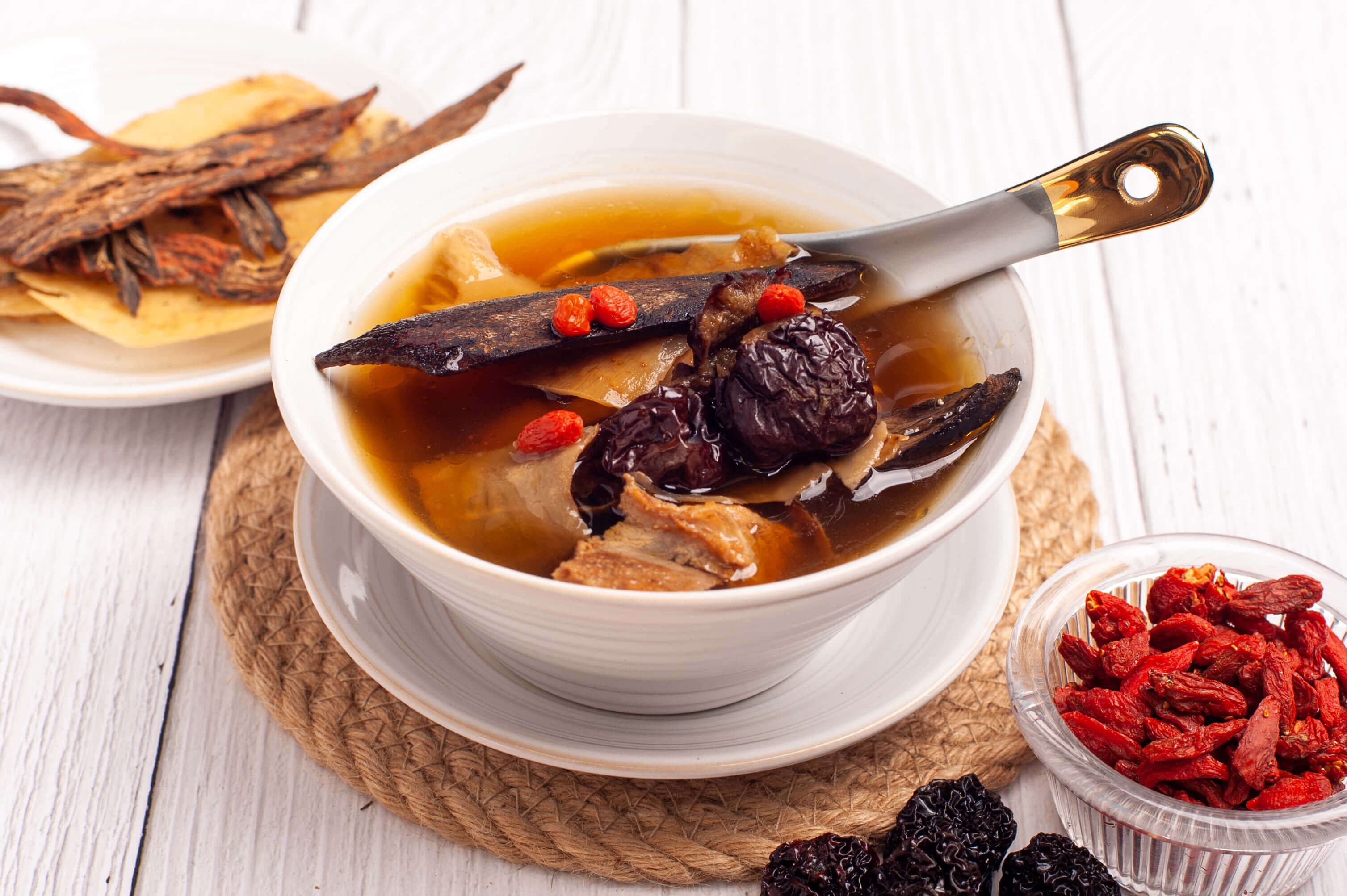 a bowl of Chinese herbal soup with red dates and goji berries