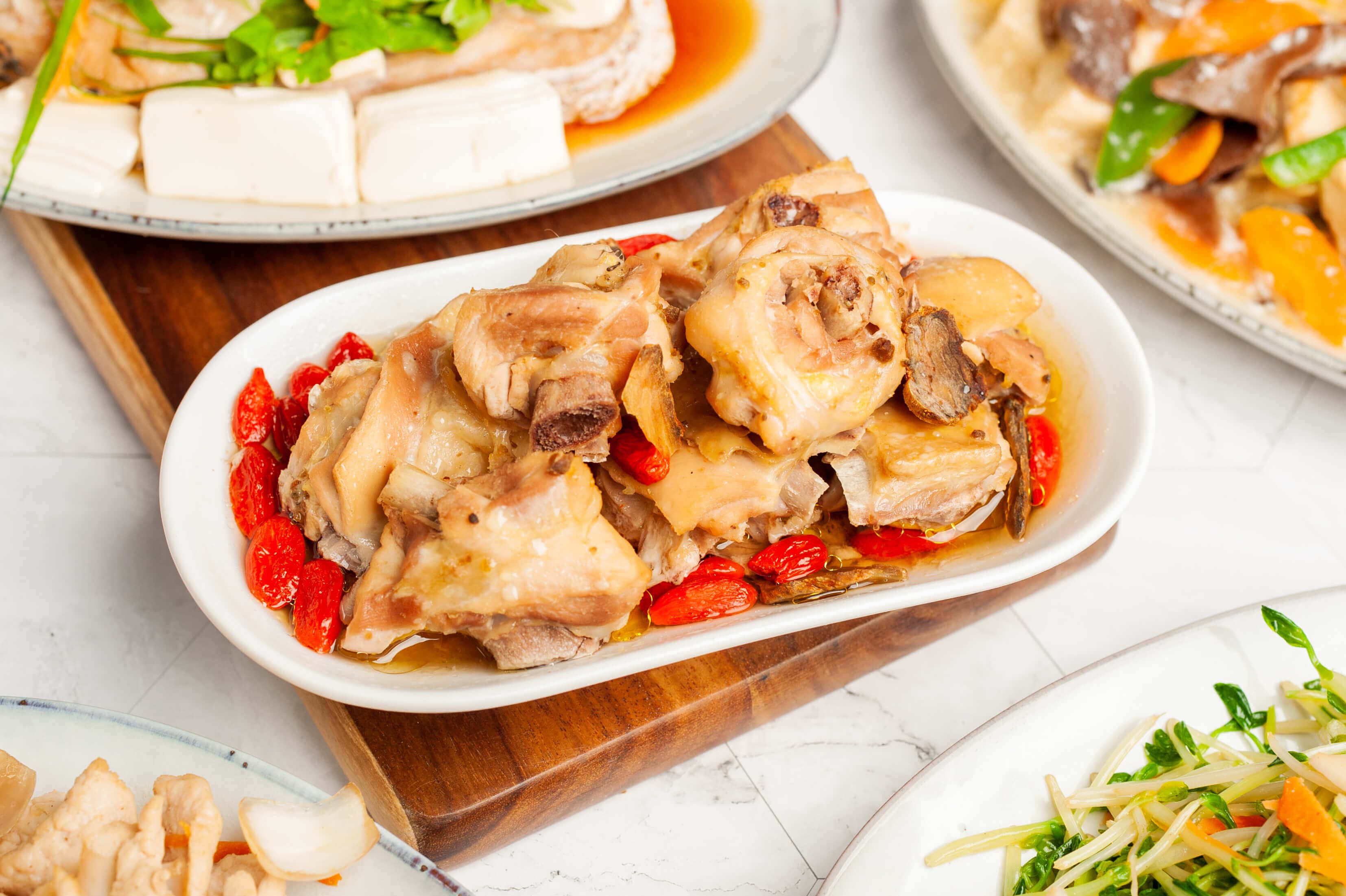 Steamed chicken with ginger and goji berries on an oval plate