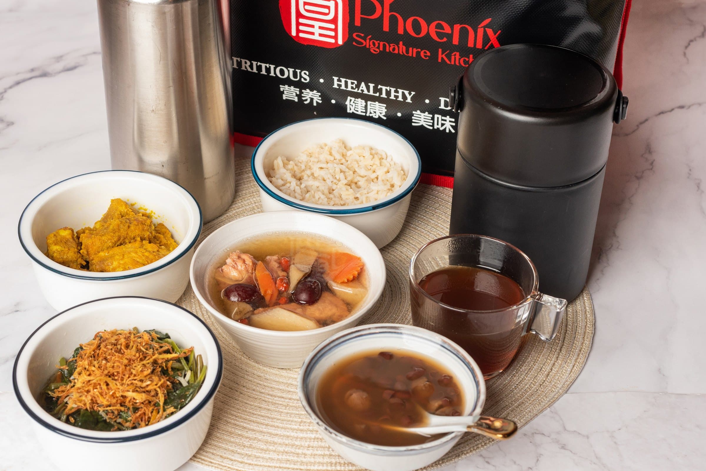 A full meal served out: soup, a main, greens, brown rice, tea and a tongsui